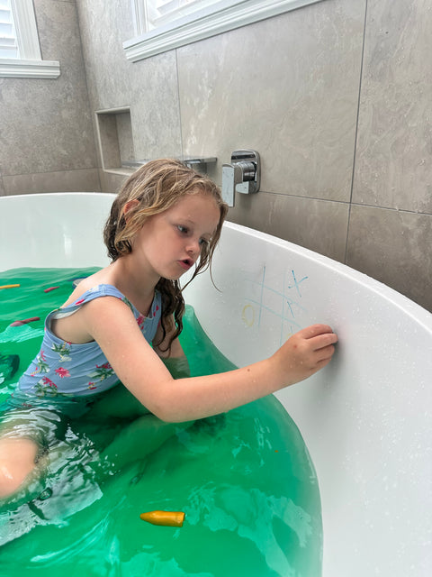 Child drawing in bath tub