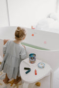 Child drawing on bath tiles using eco-friendly beeswax bath crayons