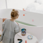 Child drawing on bath tiles using eco-friendly beeswax bath crayons